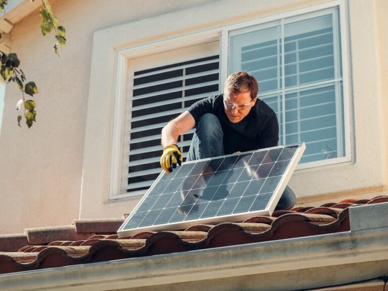 man installing solar panel on roof